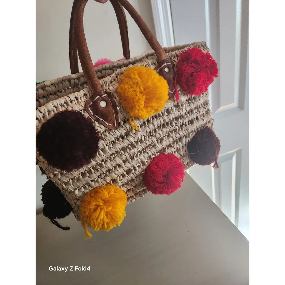 Beautiful woven straw bag with colorful pom-poms